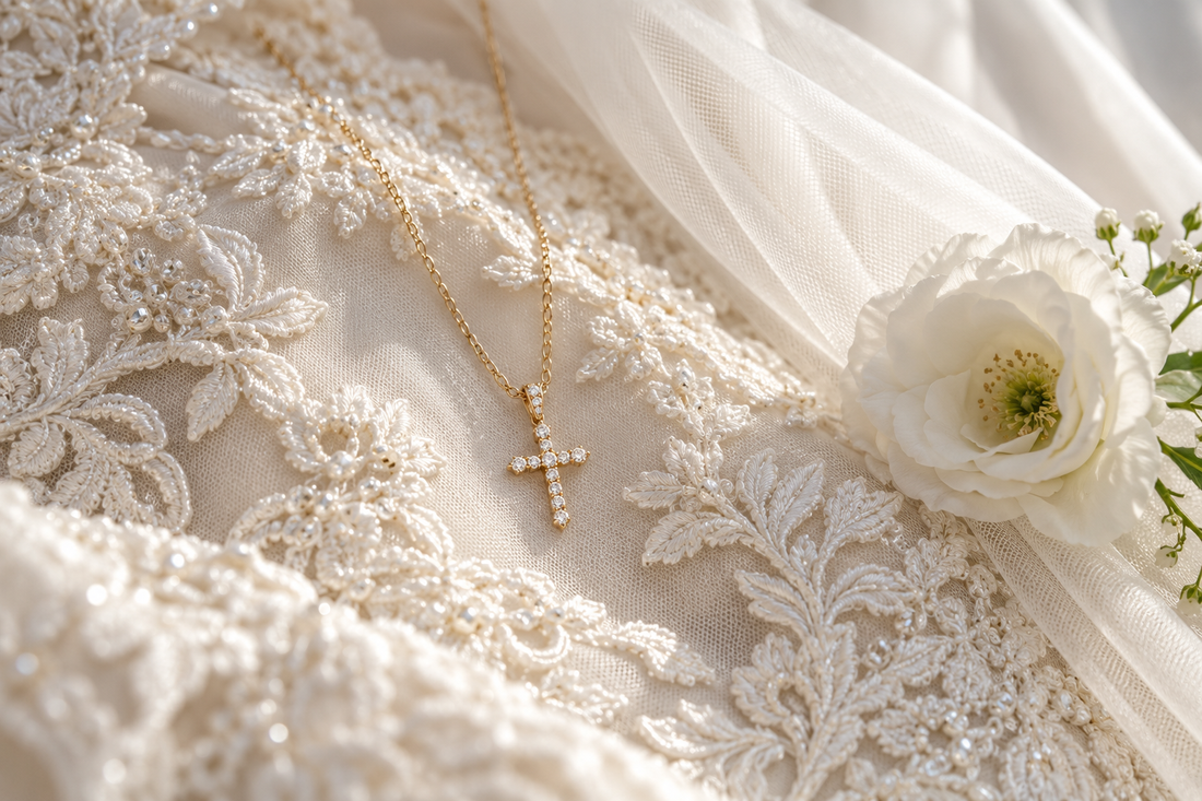 Delicate gold cross necklace arranged on an ivory wedding dress