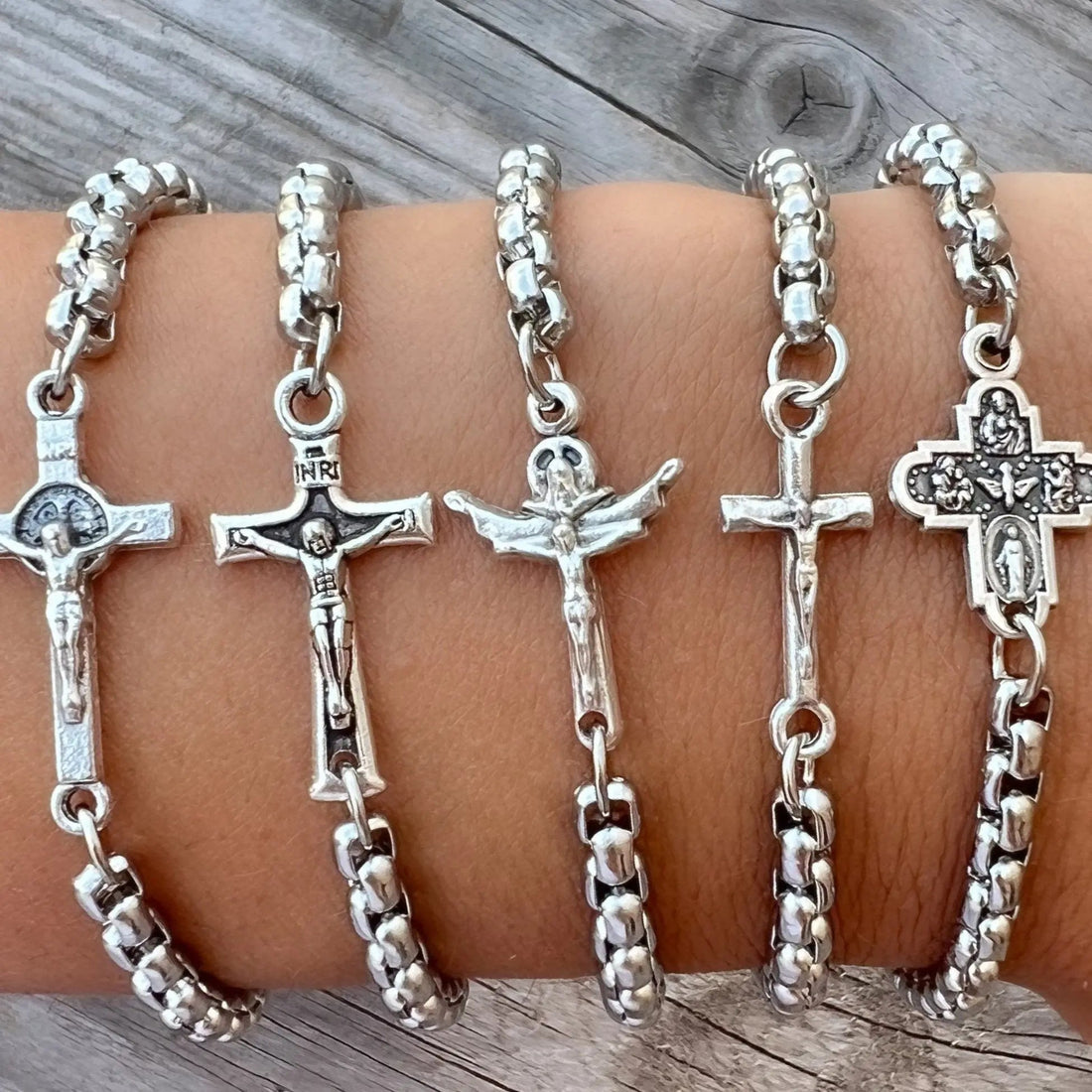 Catholic cross medal bracelet laid flat beside a measuring tape on a cream background