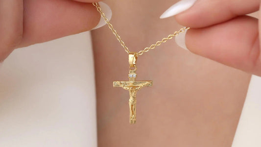 Cross pendant necklace with a two-inch extender chain arranged beside a ruler