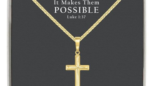 Gold-over-sterling-silver cross necklace beside a clean polishing cloth