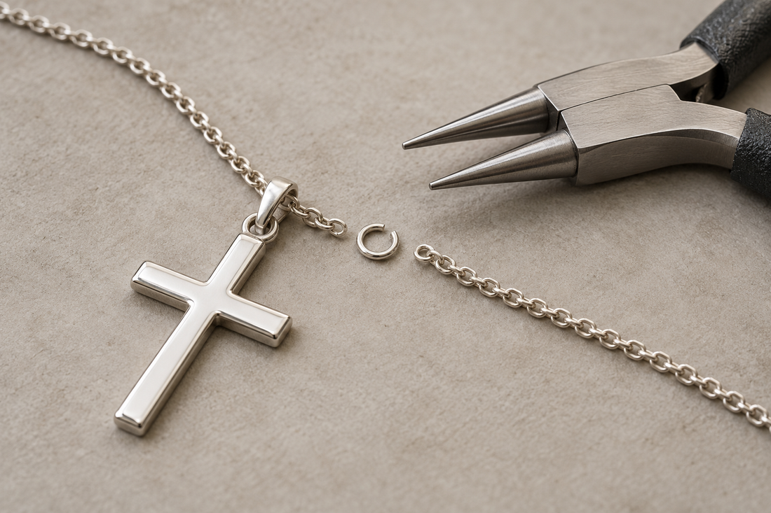 Silver cross necklace with an opened jump ring ready for repair